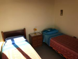 een slaapkamer met 2 bedden en een nachtkastje bij Mansarda pennisi in Le Castella