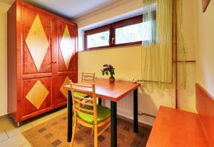 a dining room with a wooden table and chairs at Apartmány Novákovi in Dolní Morava