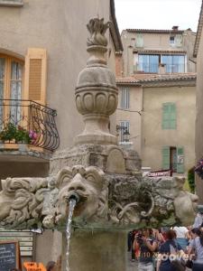 een fontein met een standbeeld van een leeuw bij Maison Village Au Coeur De La Lavande in Valensole