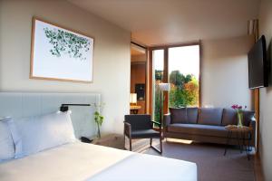 a bedroom with a bed and a living room with a couch at Hotel Arima & Spa - Small Luxury Hotels in Donostia-San Sebastián