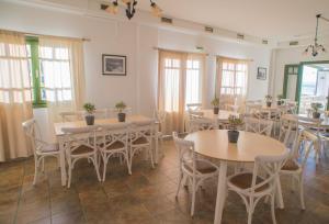a dining room with tables and chairs and windows at Ostria Hotel & Apartments in Gavrio