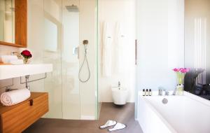 a bathroom with a shower and a sink and a tub at Hotel Arima & Spa - Small Luxury Hotels in Donostia-San Sebastián