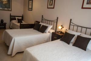 a bedroom with two beds and a lamp on a table at El Palacete in Setenil