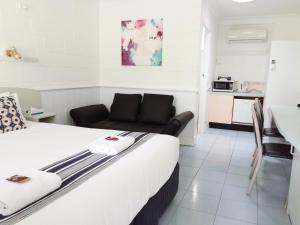 a hotel room with a bed and a kitchen at Arcadia Motel in Goonellabah
