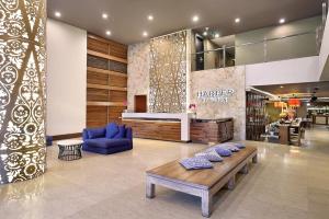 a store lobby with a blue couch and a table at Harper Kuta Hotel by ASTON in Legian