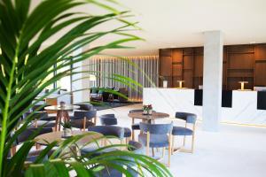 a hotel lobby with tables and chairs and plants at Hotel Arima & Spa - Small Luxury Hotels in Donostia-San Sebastián
