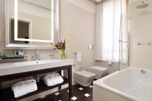 a bathroom with a sink and a toilet and a tub at Milano Castello Luxury Apartment in Milan