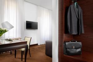 a hotel room with a desk and a table with a bag at Milano Castello Luxury Apartment in Milan