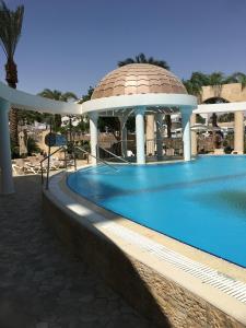 a swimming pool next to a building with a dome at GOLF2 in Eilat