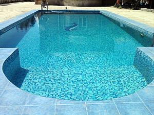 una piscina con piastrelle blu sul pavimento di Shuvelan Cottage House a Şüvǝlǝn