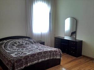 a bedroom with a bed and a mirror and a dresser at Дача 2 спальни Центр Шувелян in Şüvǝlǝn