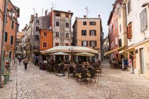 an empty street with tables and chairs and buildings at Apartman Arca in Rovinj