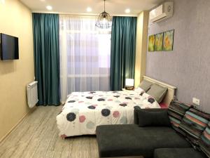 a bedroom with a bed and a couch at Panorama Sea View Studio! in Batumi
