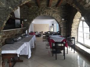 a restaurant with tables and chairs in a building at Aiolos Hotel Andros in Ménites