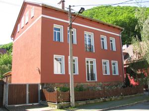 a red house with a fence and a pole at Ferienwohnung am Bodetal mit Wallbox für E-Auto in Thale