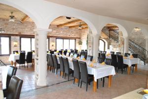 a dining room with white tables and black chairs at Guesthouse Promenade in Medulin