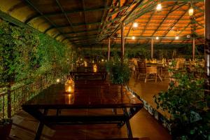 a patio with a table and chairs and plants at Petals Resorts Wayanad in Tariyod