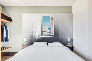 a bedroom with a large white bed and a window at B&B HOTEL Brignoles in Brignoles +41 photos
