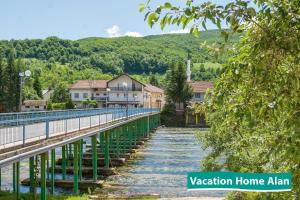 a bridge over a river with houses in the background at Vacation home Alan 2 in Kulen Vakuf