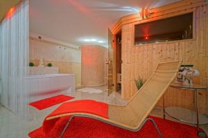 a bathroom with a red rug and a chair at Penzion Janka in Brno
