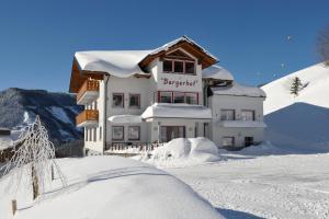 um edifício coberto de neve na frente em Bergerhof em Ramsau am Dachstein