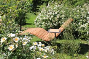 a bench sitting in the grass next to flowers at Gutshaus Gottin in Warnkenhagen