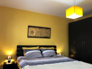 - une chambre avec un lit et un mur jaune dans l'établissement Lemon Tree Apartment, à Pristina
