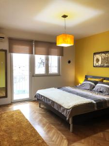 - une chambre avec un grand lit et un mur jaune dans l'établissement Lemon Tree Apartment, à Pristina