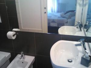 a bathroom with a sink and a toilet and a mirror at B&B Verdeblu in Mantova
