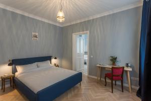 a bedroom with a bed and a table with a chair at Little Bucharest mansion next to Parliament Palace in Bucharest