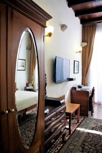 ジョージタウンにあるNam Keng Hotel Penangの鏡とベッド付きのホテルルーム