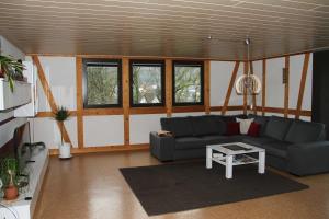 ein Wohnzimmer mit einem Sofa und einem Tisch in der Unterkunft Ferienwohnung Schlierbachtal in Lindenfels