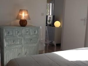 a bedroom with a dresser with a lamp on it at Meublé La Sergerie in Le Lavandou +22 photos