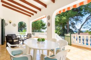 Villa Canela b11 في سانتو توماس: غرفة طعام مع طاولة بيضاء وكراسي