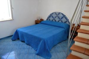 una camera con letto e piumone blu di Maridea - Spiaggia Sant' Antonio a Ponza