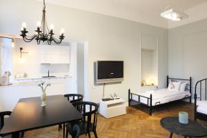 a living room with a dining table and a tv at Faust Apartments in the Heart of Kazimierz in Krakow