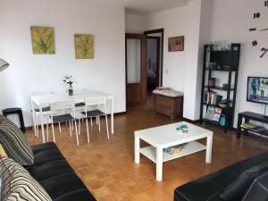 sala de estar con sofá, mesa y sillas en Apartamento en Colombres, en Colombres