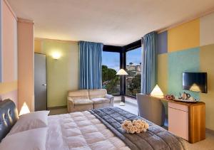 a bedroom with a bed and a chair and a television at Albornoz Palace Hotel in Spoleto