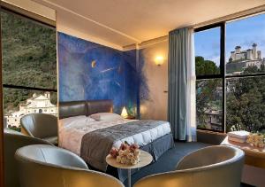 a bedroom with a bed and a table with chairs at Albornoz Palace Hotel in Spoleto