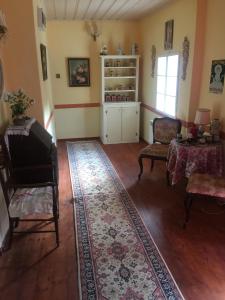 ein Wohnzimmer mit einem Klavier und einem Tisch in der Unterkunft The Pink House in Polkownik Serafinowo