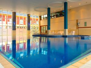 a swimming pool with blue water in a building at Lady Gregory Hotel, Leisure Club & Beauty Rooms in Gort