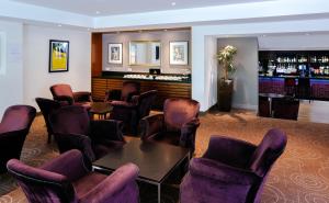 a waiting room with chairs and a bar at Aubrey Park Hotel in Hemel Hempstead