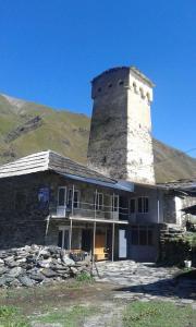un edificio con una torre en la cima de una montaña en Old Tower Ushguli, en Ushguli