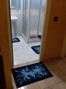 ein Badezimmer mit einer Dusche und einem blauen Teppich in der Unterkunft Agadir jet sakane 1 er étage in Agadir