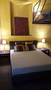ein Schlafzimmer mit einem Bett mit zwei Lampen auf beiden Seiten in der Unterkunft "Piazza Vittoria"Pavia SPLENDIDA Dimora in Pavia