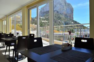 a restaurant with tables and chairs and a large window at Hotel Porto Calpe in Calpe