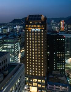 ein beleuchtetes Gebäude in einer Stadt in der Nacht in der Unterkunft ENA Suite Hotel Namdaemun in Seoul