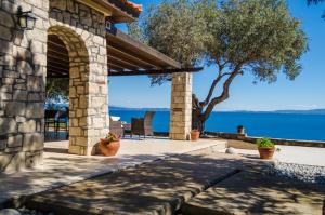 a stone house with a view at Nissi View Villa in Vourvourou