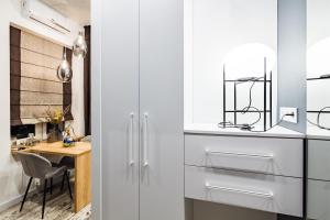 a kitchen with white cabinets and a dining table at Arkadija - Filatova in Lviv +25 photos