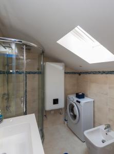 a bathroom with a shower and a washing machine at Blue Sea Apartment by Locap Group in Piran +20 photos